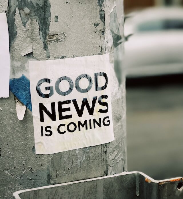 Birkenstamm mit Plakat, darauf der Text "Good News is Coming".