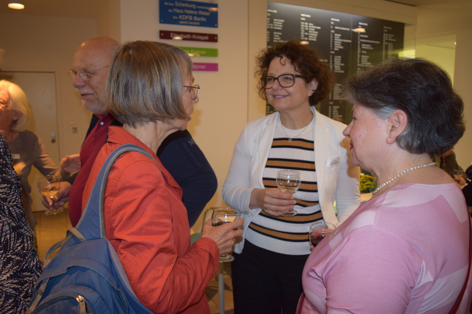 Gesprächssituation im Foyer des Hauses Helene Weber. Drei Frauen, in der Mitte Dr. Monika Arzberger, Vizepräsidentin des KDFB-Bundesverbandes, unterhalten sich mit Weingläsern in der Hand.