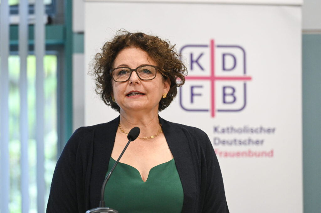 Vor dem Rollup des Katholischen Deutschen Frauenbundes steht die KDFB-Vizepräsidentin Monika Arzberger und spricht in ein Mikrofon.